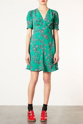 Model in green tea dress and red shoes